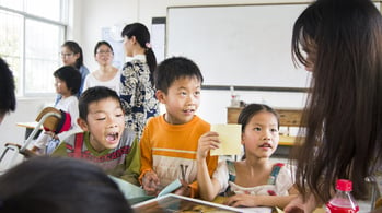 3 elementary students listen closely to their teacher